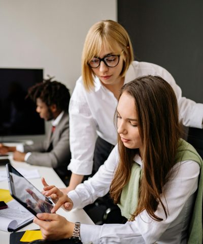 Team reviewing information on a tablet during a collaborative office meeting.